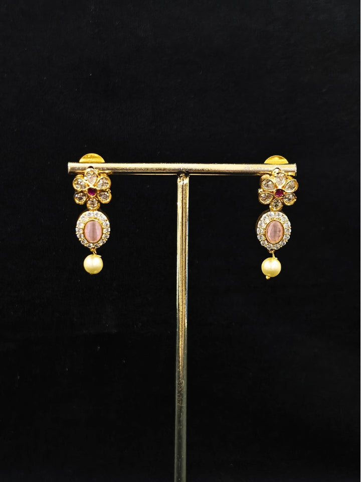 Close-up of an ornate traditional Mint Pink (gold Polish) Collar jewellery set and earrings with American diamonds, Pearls and Colored Stones. Festive Diwali outfit styled with an American diamond artificial necklace. Elegant wedding jewelry look featuring a premium artificial American diamond necklace. 