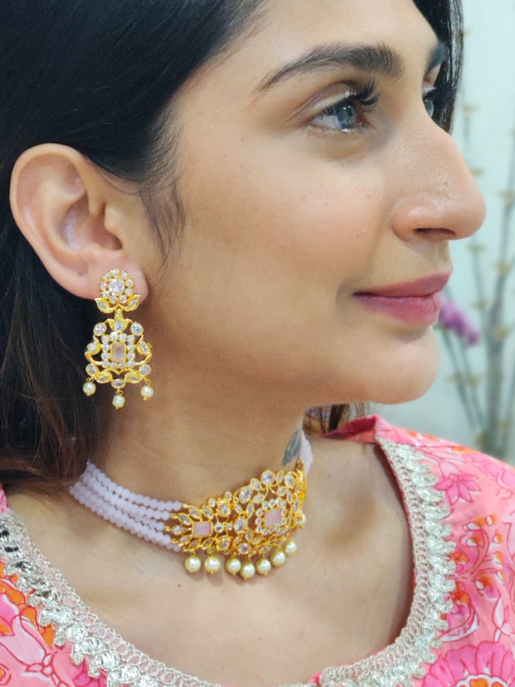 A woman with long brown hair wears the Mint Pink Sarah choker Necklace Set, featuring an ornate crystal-beaded choker with gold and pearl details and matching gold earrings. She has a neutral expression and wears a light-colored top.