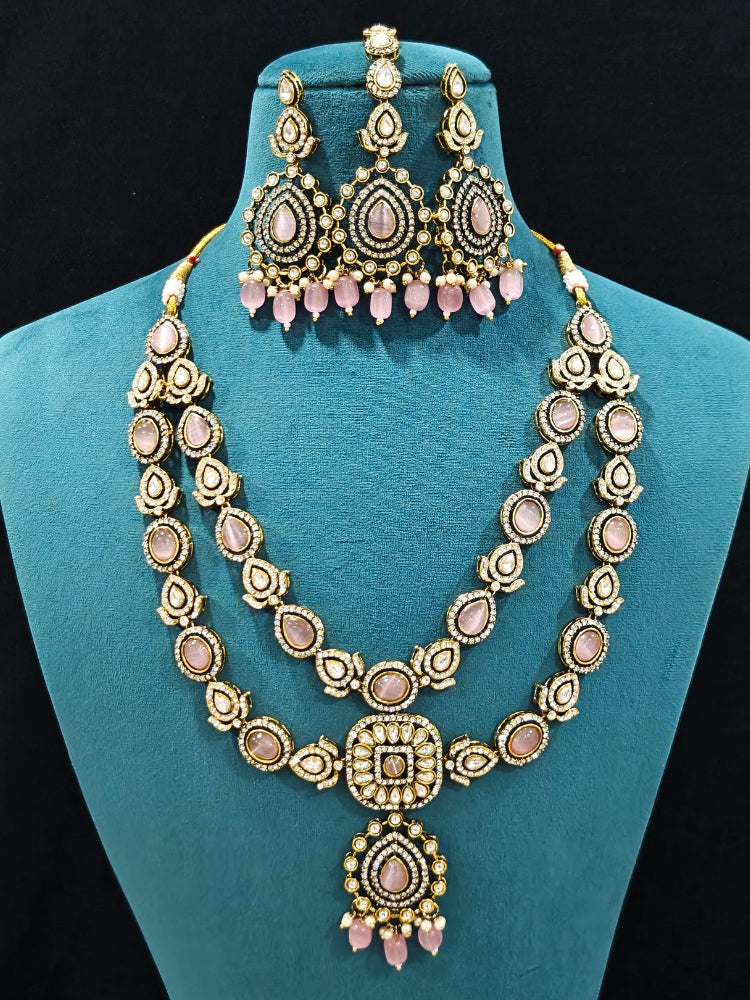 Close-up of an ornate traditional Mint Pink Diamond Collar Layered jewellery set and earrings and maangtikka with Kundan, American Diamonds, Tumble stones, Black Polish and Colored Stones. A luxury American diamond necklace set styled beautifully for a wedding guest look in India. Close-up of a bridal look featuring an anti-tarnish American diamond artificial necklace.