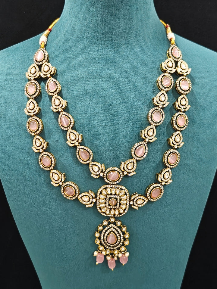Close-up of an ornate traditional Mint Pink Diamond Collar Layered jewellery set and earrings and maangtikka with Kundan, American Diamonds, Tumble stones, Black Polish and Colored Stones. A luxury American diamond necklace set styled beautifully for a wedding guest look in India. Close-up of a bridal look featuring an anti-tarnish American diamond artificial necklace.