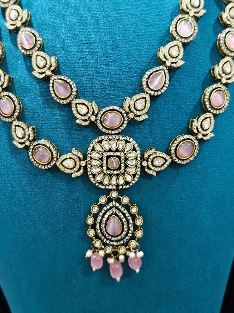 Close-up of an ornate traditional Mint Pink Diamond Collar Layered jewellery set and earrings and maangtikka with Kundan, American Diamonds, Tumble stones, Black Polish and Colored Stones. A luxury American diamond necklace set styled beautifully for a wedding guest look in India. Close-up of a bridal look featuring an anti-tarnish American diamond artificial necklace.