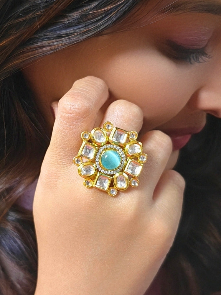Close-up of a woman wearing an ornate traditional (Gold Polish) Mint Blue Ring with Kundan, Colored Stones and American Diamond. Bride wearing a royal Kundan artificial ring for wedding rituals. Wedding celebration look enhanced with a statement Kundan Ring.