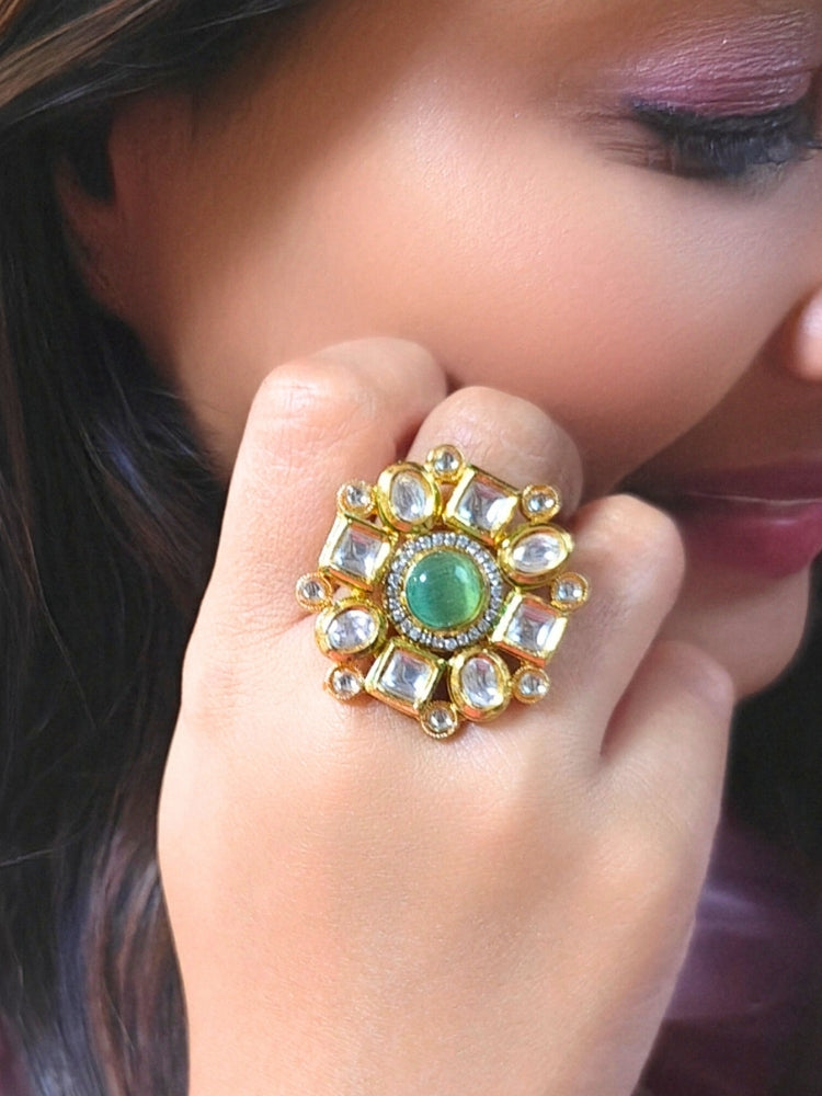 Close-up of a woman wearing an ornate traditional (Gold Polish) Mint Green Ring with Kundan, Colored Stones and American Diamond. Bride wearing a royal Kundan artificial ring for wedding rituals. Wedding celebration look enhanced with a statement Kundan Ring.