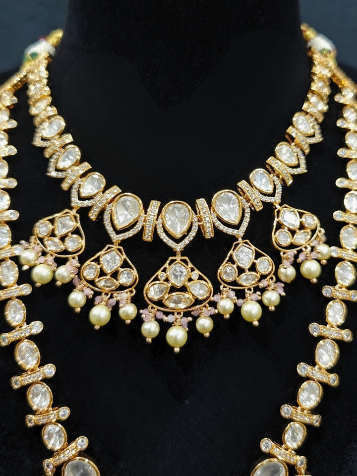 Close-up of an ornate traditional (Gold Polish) Long jewellery set and earrings with Polki, American Diamond, Tumble Beads and Pearls. Festive celebration look completed with premium imitation Polki jewelry. Woman wearing trending Polki artificial jewelry for the wedding season in India.