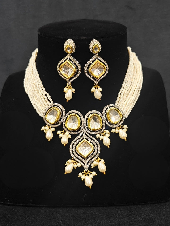 Close-up of an ornate traditional White Kundan Collar jewellery set and earrings with Moissanite Stones, American Diamonds, Pearls and Kundan. Reception party outfit paired with a luxury Kundan imitation jewelry set. Wedding celebration look enhanced with a statement Kundan necklace.