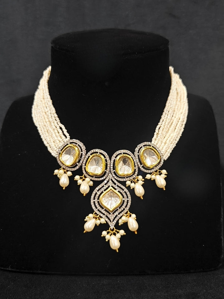Close-up of an ornate traditional White Kundan Collar jewellery set and earrings with Moissanite Stones, American Diamonds, Pearls and Kundan. Reception party outfit paired with a luxury Kundan imitation jewelry set. Wedding celebration look enhanced with a statement Kundan necklace.