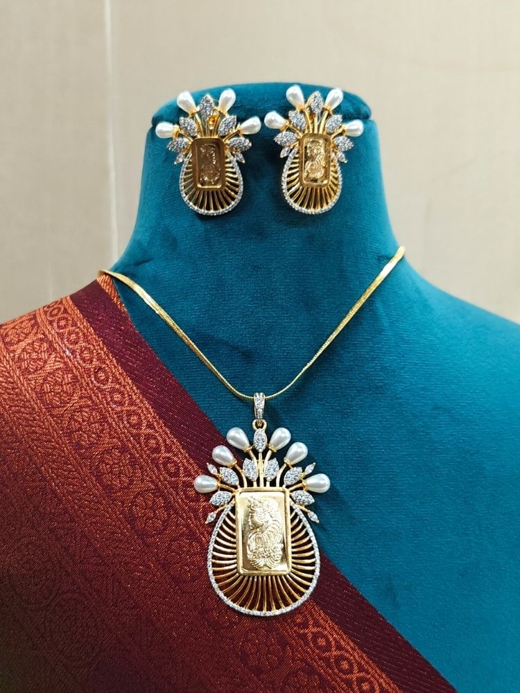 Close-up of an ornate traditional (Bright Gold Polish) Ginni jewellery set and earrings with American Diamond and Pearls. Party wear outfit completed with a lightweight American diamond Pendant Set. Close-up of a cocktail party look featuring a premium American diamond Pendant.