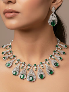 Close-up of a woman wearing an ornate Western Green Diamond Silver Collar jewellery set and earrings with American Diamond and Green Colored Stones. A woman wearing a luxury American diamond necklace set styled beautifully for a wedding guest look in India. Elegant wedding jewelry look featuring a premium artificial American diamond necklace.