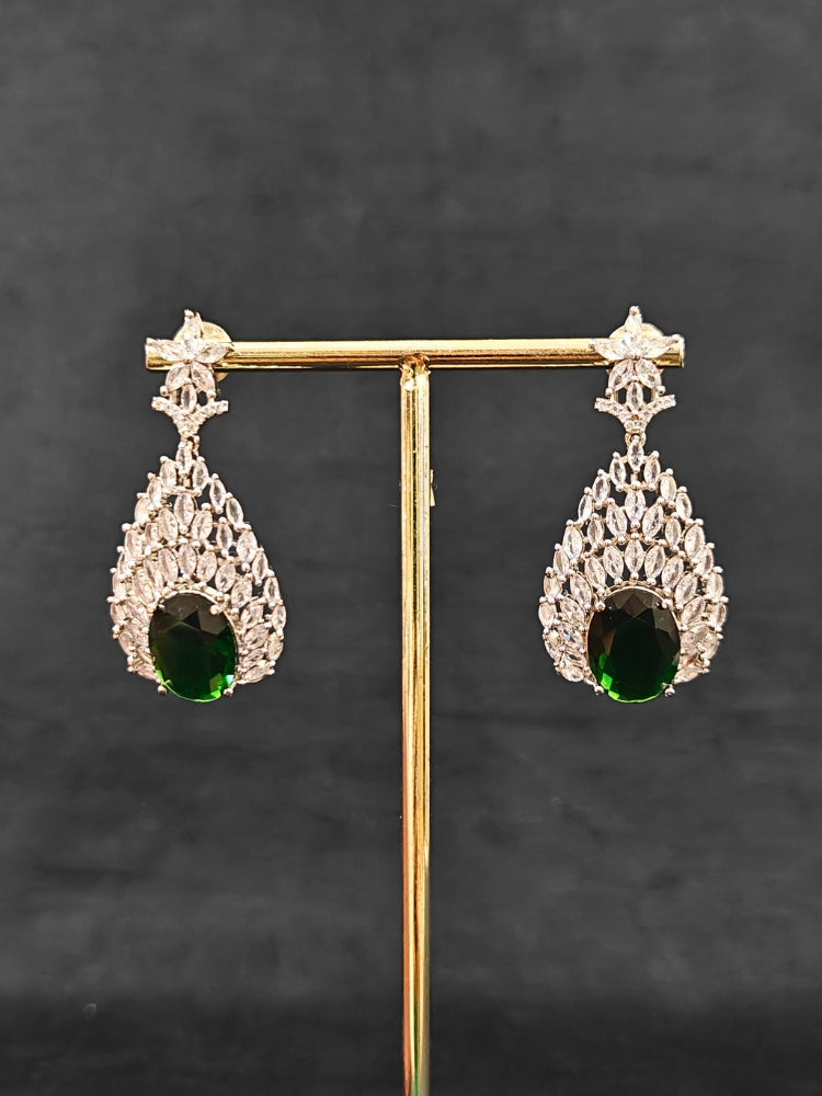 Close-up of an ornate Western Green Diamond Silver Collar jewellery set and earrings with American Diamond and Green Colored Stones. A luxury American diamond necklace set styled beautifully for a wedding guest look in India. Elegant wedding jewelry look featuring a premium artificial American diamond necklace.