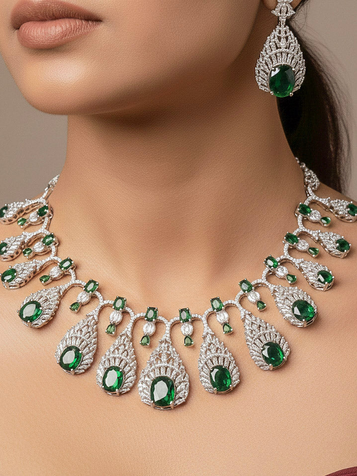 Close-up of a woman wearing an ornate Western Green Diamond Silver Collar jewellery set and earrings with American Diamond and Green Colored Stones. A woman wearing a luxury American diamond necklace set styled beautifully for a wedding guest look in India. Elegant wedding jewelry look featuring a premium artificial American diamond necklace.