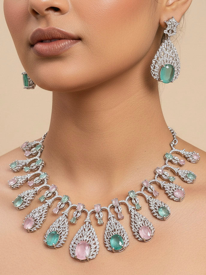 Close-up of a woman wearing an ornate Western Pink & Green Diamond Silver Collar jewellery set and earrings with American Diamond and Colored Stones. A woman wearing a luxury American diamond necklace set styled beautifully for a wedding guest look in India. Elegant wedding jewelry look featuring a premium artificial American diamond necklace.