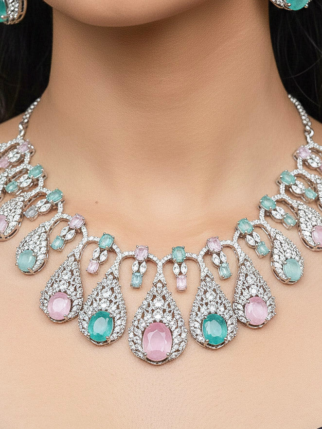 Close-up of a woman wearing an ornate Western Pink & Green Diamond Silver Collar jewellery set and earrings with American Diamond and Colored Stones. A woman wearing a luxury American diamond necklace set styled beautifully for a wedding guest look in India. Elegant wedding jewelry look featuring a premium artificial American diamond necklace.