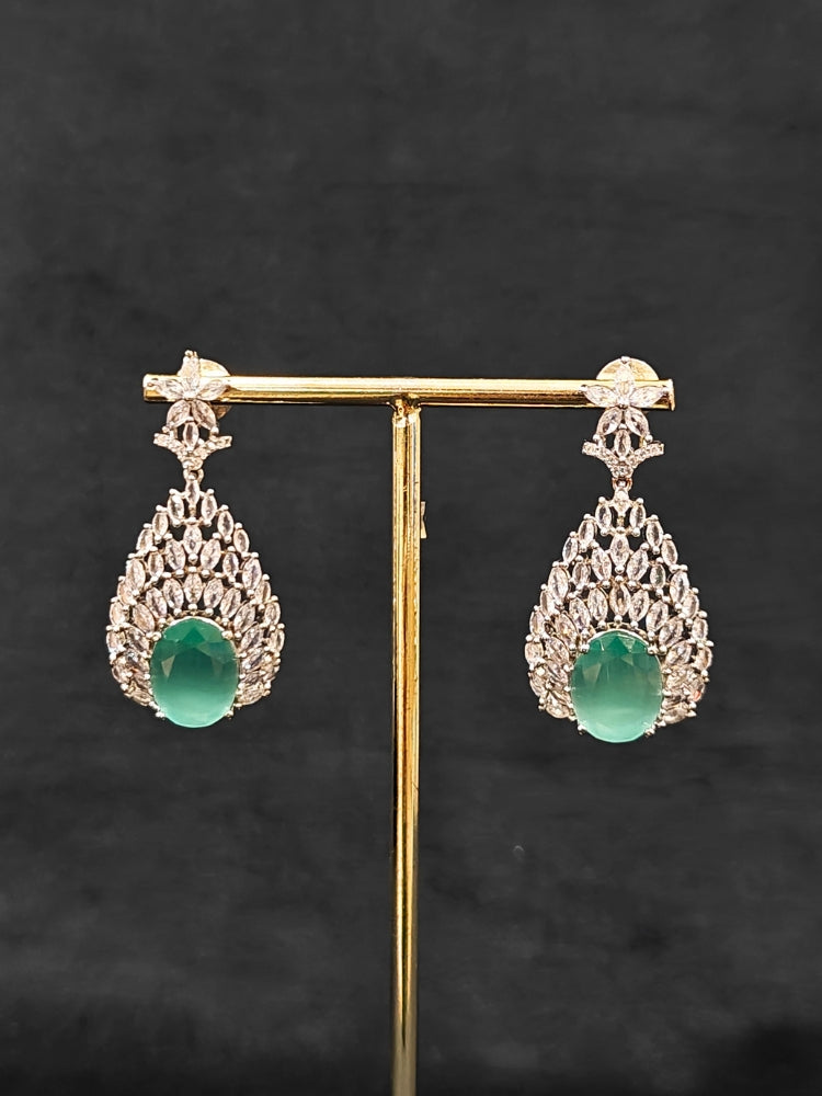 Close-up of an ornate Western Pink & Green Diamond Silver Collar jewellery set and earrings with American Diamond and Colored Stones. A luxury American diamond necklace set styled beautifully for a wedding guest look in India. Elegant wedding jewelry look featuring a premium artificial American diamond necklace.