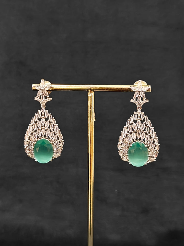 Close-up of an ornate Western Pink & Green Diamond Silver Collar jewellery set and earrings with American Diamond and Colored Stones. A luxury American diamond necklace set styled beautifully for a wedding guest look in India. Elegant wedding jewelry look featuring a premium artificial American diamond necklace.