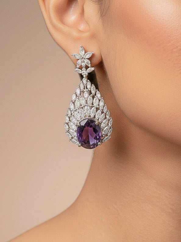 Close-up of a woman wearing an ornate Western Purple Diamond Silver Collar jewellery set and earrings with American Diamond and Purple Colored Stones. A woman wearing a luxury American diamond necklace set styled beautifully for a wedding guest look in India. Elegant wedding jewelry look featuring a premium artificial American diamond necklace.