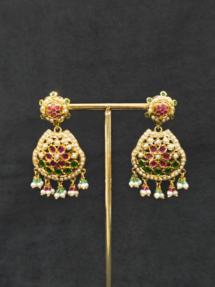 Close-up of an ornate traditional Collar jadau gold jewellery set and jadau earrings with Pearl and Pink and Green gemstones. Festive saree look completed with a handcrafted Jadau necklace.
Festive celebration look featuring a Jadau artificial necklace.