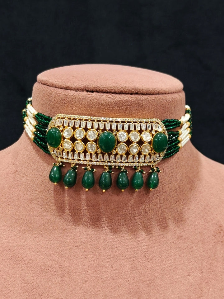 Close-up of an ornate traditional (Gold Polish) Choker Dark Green jewellery set and earrings with Crystal Beads, Polki, American Diamond, Colored Stones and Pearls. Festive Diwali look enhanced with a premium Polki artificial necklace. Festive saree look completed with Polki artificial jewelry set.