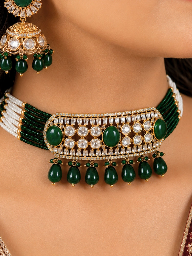 Close-up of a woman wearing an ornate traditional (Gold Polish) Choker Dark Green jewellery set and earrings with Crystal Beads, Polki, American Diamond, Colored Stones and Pearls. Festive Diwali look enhanced with a premium Polki artificial necklace. Festive saree look completed with Polki artificial jewelry set.