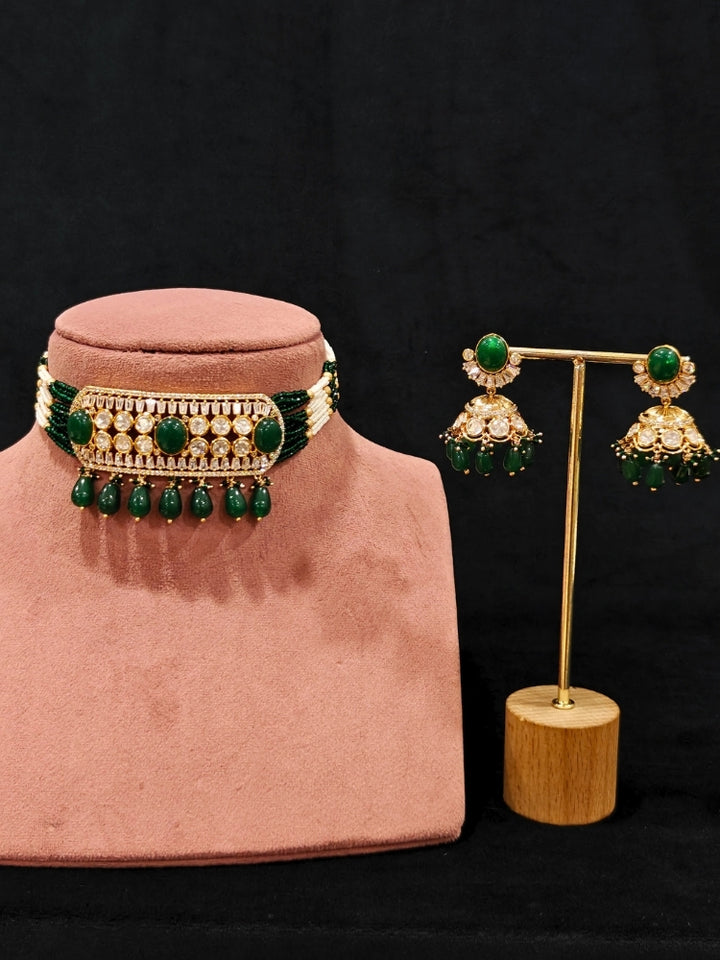 Close-up of an ornate traditional (Gold Polish) Choker Dark Green jewellery set and earrings with Crystal Beads, Polki, American Diamond, Colored Stones and Pearls. Festive Diwali look enhanced with a premium Polki artificial necklace. Festive saree look completed with Polki artificial jewelry set.