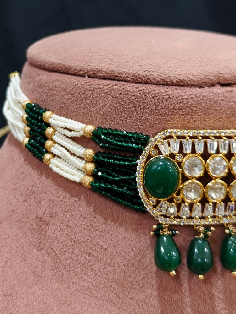 Close-up of an ornate traditional (Gold Polish) Choker Dark Green jewellery set and earrings with Crystal Beads, Polki, American Diamond, Colored Stones and Pearls. Festive Diwali look enhanced with a premium Polki artificial necklace. Festive saree look completed with Polki artificial jewelry set.
