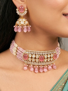 Close-up of a woman wearing an ornate traditional (Gold Polish) Choker Mint Pink jewellery set and earrings with Crystal Beads, Polki, American Diamond, Colored Stones and Pearls. Festive Diwali look enhanced with a premium Polki artificial necklace. Festive saree look completed with Polki artificial jewelry set.
