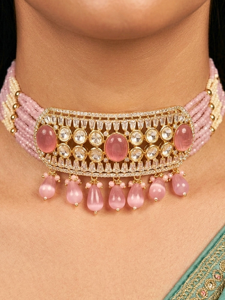 Close-up of a woman wearing an ornate traditional (Gold Polish) Choker Mint Pink jewellery set and earrings with Crystal Beads, Polki, American Diamond, Colored Stones and Pearls. Festive Diwali look enhanced with a premium Polki artificial necklace. Festive saree look completed with Polki artificial jewelry set.