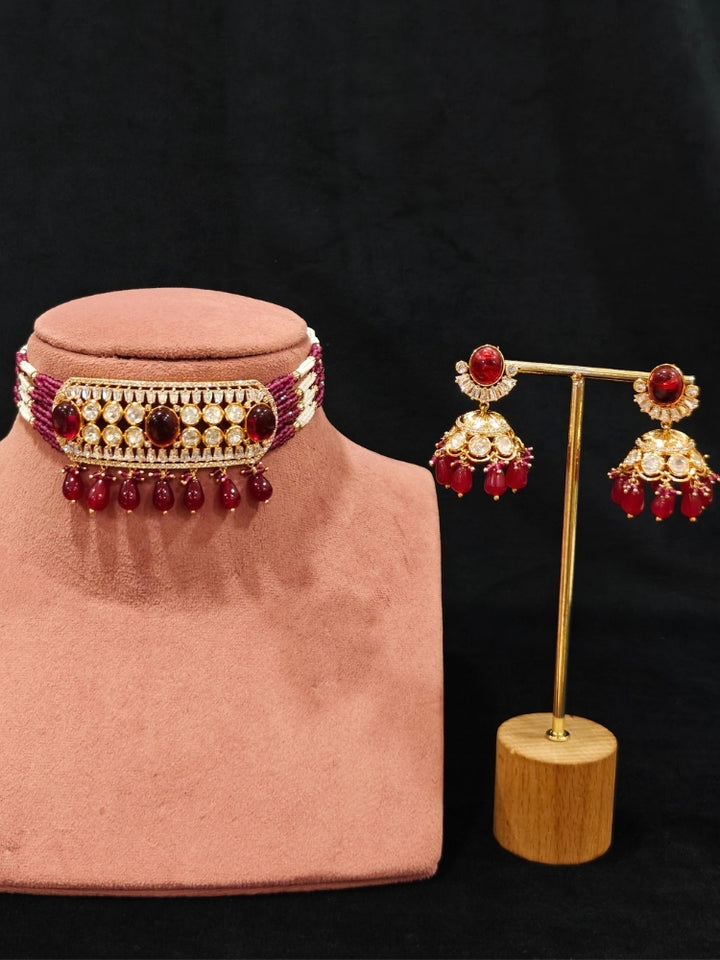 Close-up of an ornate traditional (Gold Polish) Choker Ruby Pink jewellery set and earrings with Crystal Beads, Polki, American Diamond, Colored Stones and Pearls. Festive Diwali look enhanced with a premium Polki artificial necklace. Festive saree look completed with Polki artificial jewelry set.