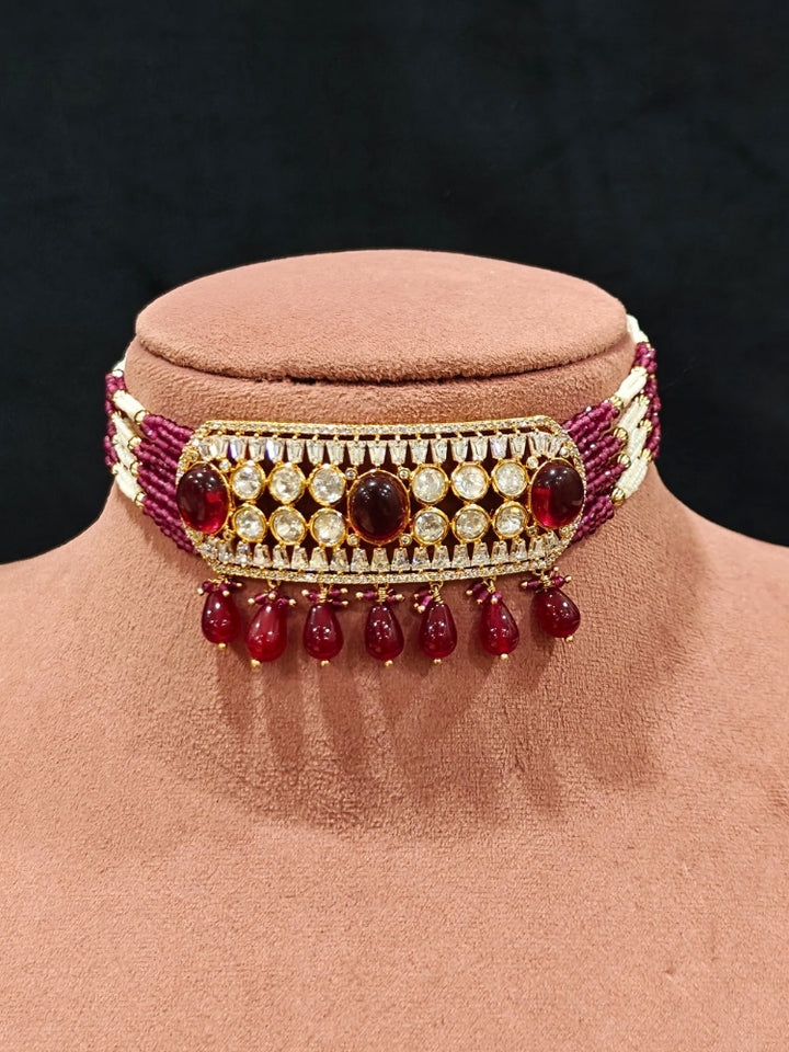 Close-up of an ornate traditional (Gold Polish) Choker Ruby Pink jewellery set and earrings with Crystal Beads, Polki, American Diamond, Colored Stones and Pearls. Festive Diwali look enhanced with a premium Polki artificial necklace. Festive saree look completed with Polki artificial jewelry set.
