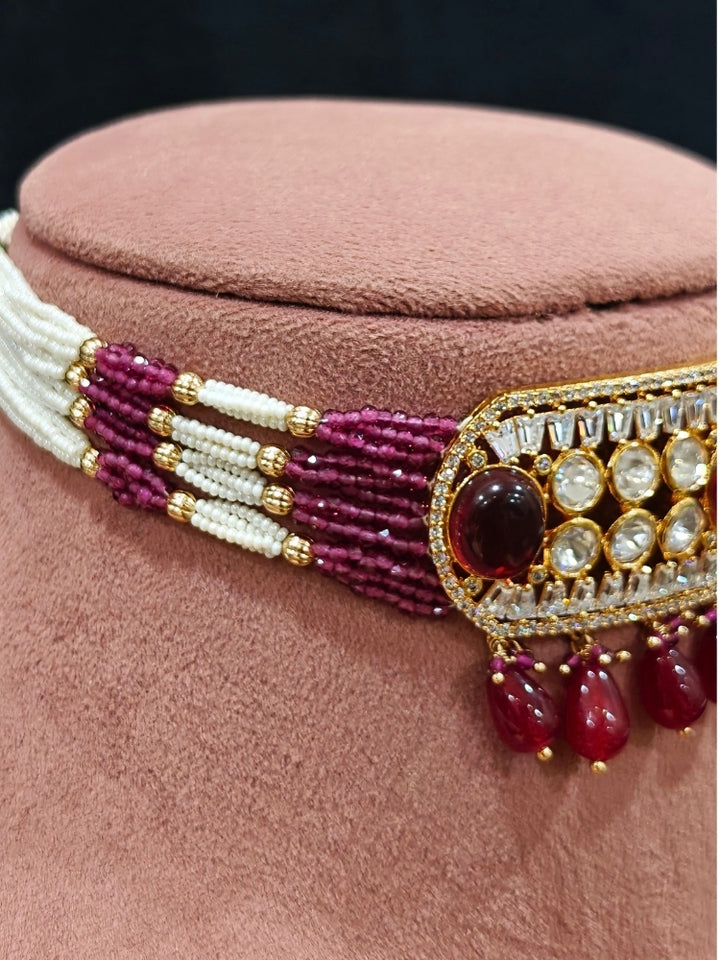 Close-up of an ornate traditional (Gold Polish) Choker Ruby Pink jewellery set and earrings with Crystal Beads, Polki, American Diamond, Colored Stones and Pearls. Festive Diwali look enhanced with a premium Polki artificial necklace. Festive saree look completed with Polki artificial jewelry set.