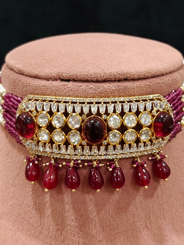 Close-up of an ornate traditional (Gold Polish) Choker Ruby Pink jewellery set and earrings with Crystal Beads, Polki, American Diamond, Colored Stones and Pearls. Festive Diwali look enhanced with a premium Polki artificial necklace. Festive saree look completed with Polki artificial jewelry set.
