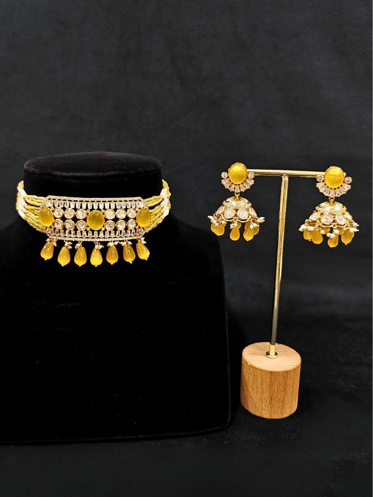 Close-up of an ornate traditional (Gold Polish) Choker Yellow jewellery set and earrings with Crystal Beads, Polki, American Diamond, Colored Stones and Pearls. Festive Diwali look enhanced with a premium Polki artificial necklace. Festive saree look completed with Polki artificial jewelry set.