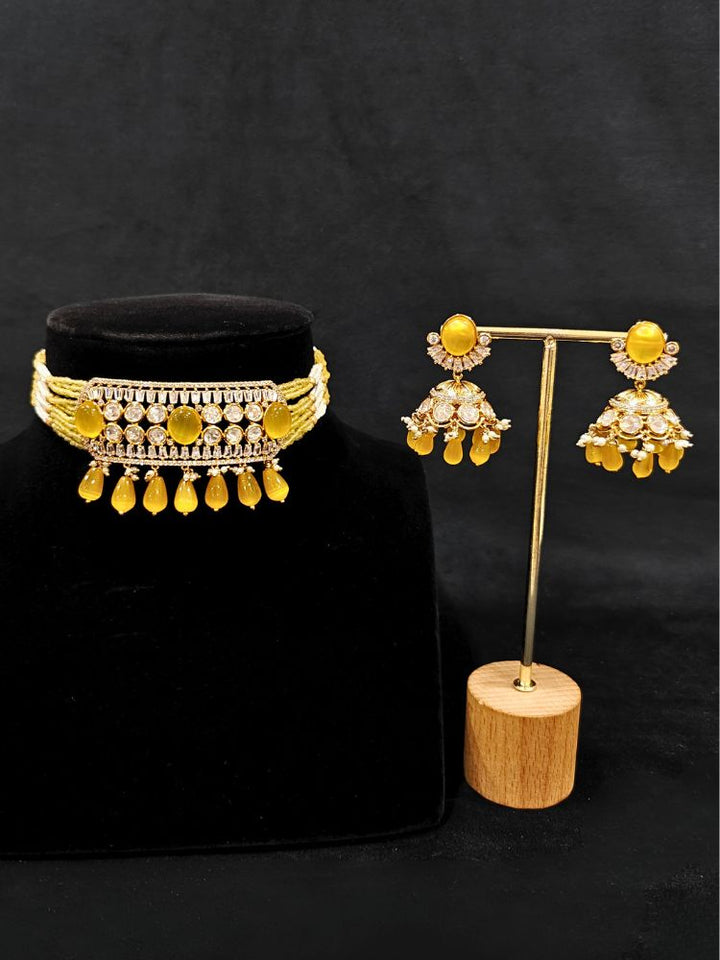 Close-up of an ornate traditional (Gold Polish) Choker Yellow jewellery set and earrings with Crystal Beads, Polki, American Diamond, Colored Stones and Pearls. Festive Diwali look enhanced with a premium Polki artificial necklace. Festive saree look completed with Polki artificial jewelry set.