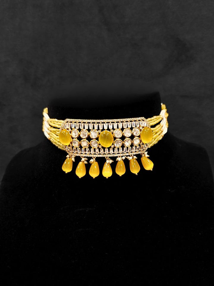 Close-up of an ornate traditional (Gold Polish) Choker Yellow jewellery set and earrings with Crystal Beads, Polki, American Diamond, Colored Stones and Pearls. Festive Diwali look enhanced with a premium Polki artificial necklace. Festive saree look completed with Polki artificial jewelry set.