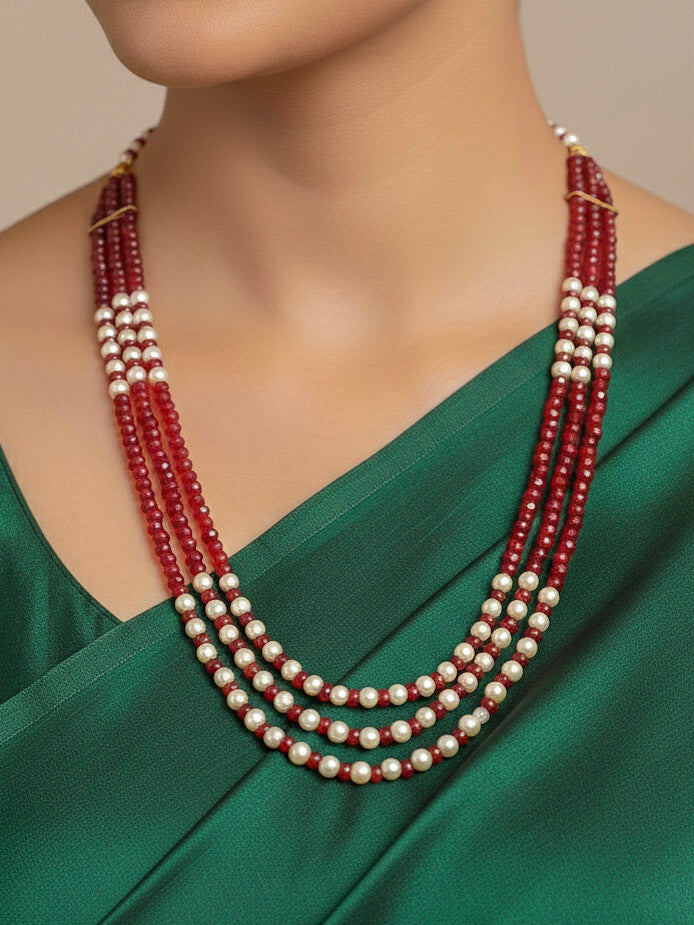 Close-up of a woman wearing an ornate traditional Red & White Layered Jewellery set and Earring with Pearls and Crystal Beads. Mehendi ceremony look completed with a handcrafted Pearl jewelry set. Mehendi ceremony look completed with a handcrafted Pearl jewelry set.