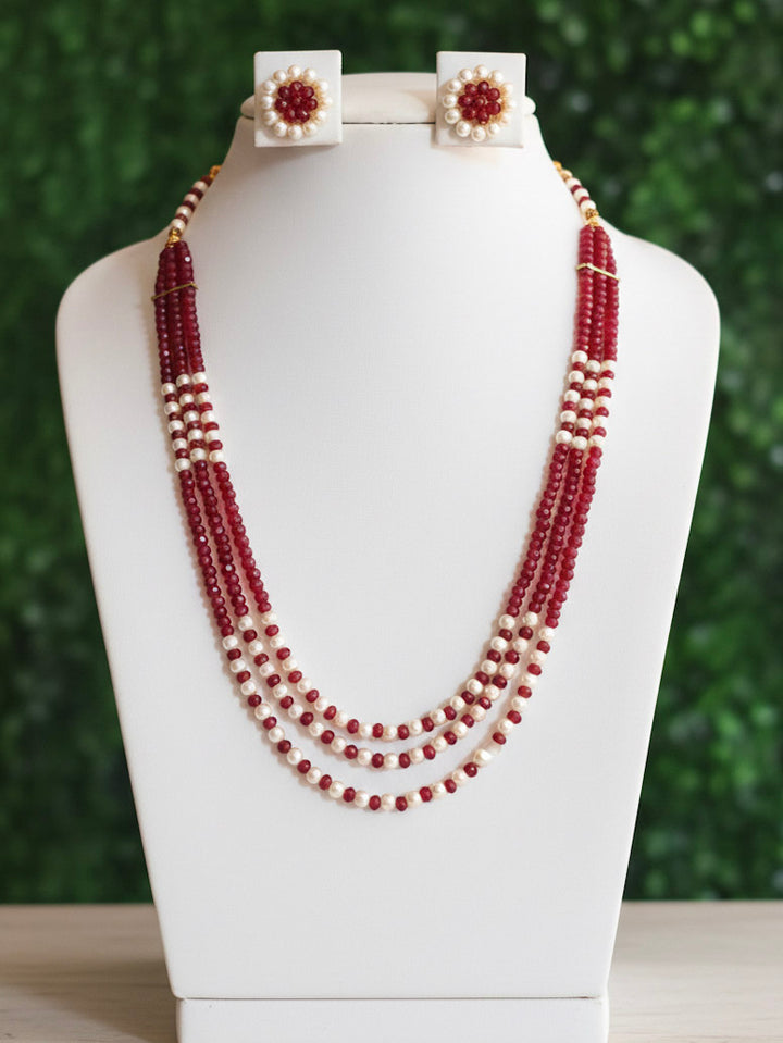 Close-up of an ornate traditional Red & White Layered Jewellery set and Earring with Pearls and Crystal Beads. Mehendi ceremony look completed with a handcrafted Pearl jewelry set. Mehendi ceremony look completed with a handcrafted Pearl jewelry set.
