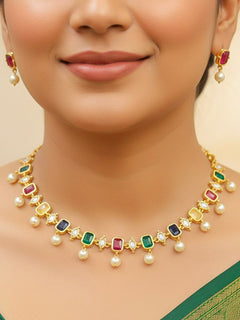 Close-up of a woman wearing an ornate traditional (Gold Polish) Multi-color Choker jewellery set and earrings with Colored Stones, Pearl and American Diamonds. Festive Diwali outfit styled with an Colored Stones artificial necklace. Mehendi function outfit styled with a Colored Stone  necklace set.