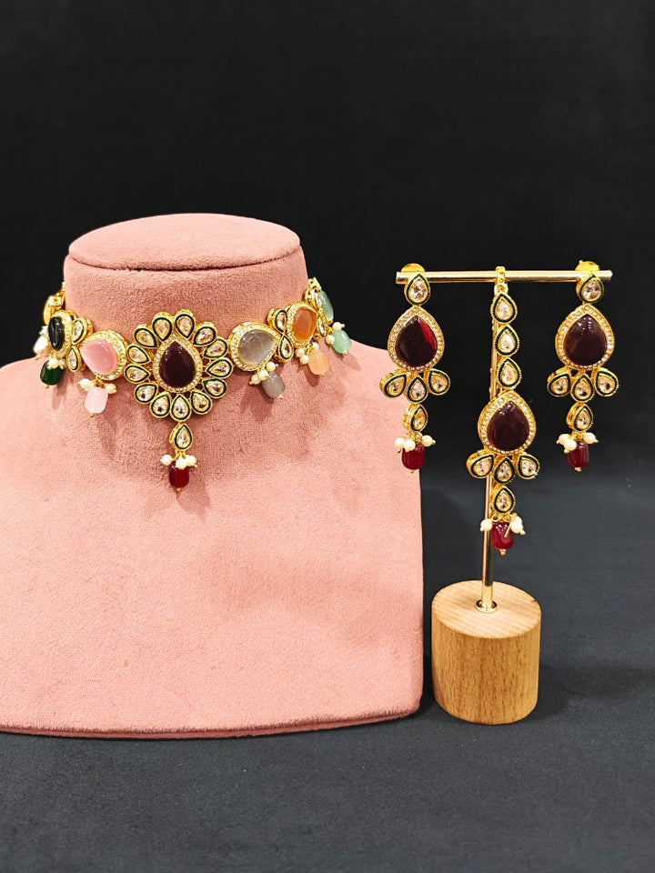 Close-up of an ornate traditional Multi-Color Choker jewellery set and earrings and maangtikka with Kundan, Monalisa Stone, American Diamonds, Beads and Reverse American Diamonds and tumble stones. A graceful woman wearing a trending Colored Stone necklace for a 2026 wedding celebration. Elegant wedding jewelry look featuring a premium artificial Colored Stone necklace.