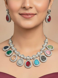 Close-up of a woman wearing an ornate Indo-western American Diamond Multi-Color Collar jewellery set and earrings with American Diamonds and Monalisa Stones. Woman styling a statement American diamond necklace with an off-shoulder gown for a reception. Close-up of a luxury American Diamond imitation necklace styled.