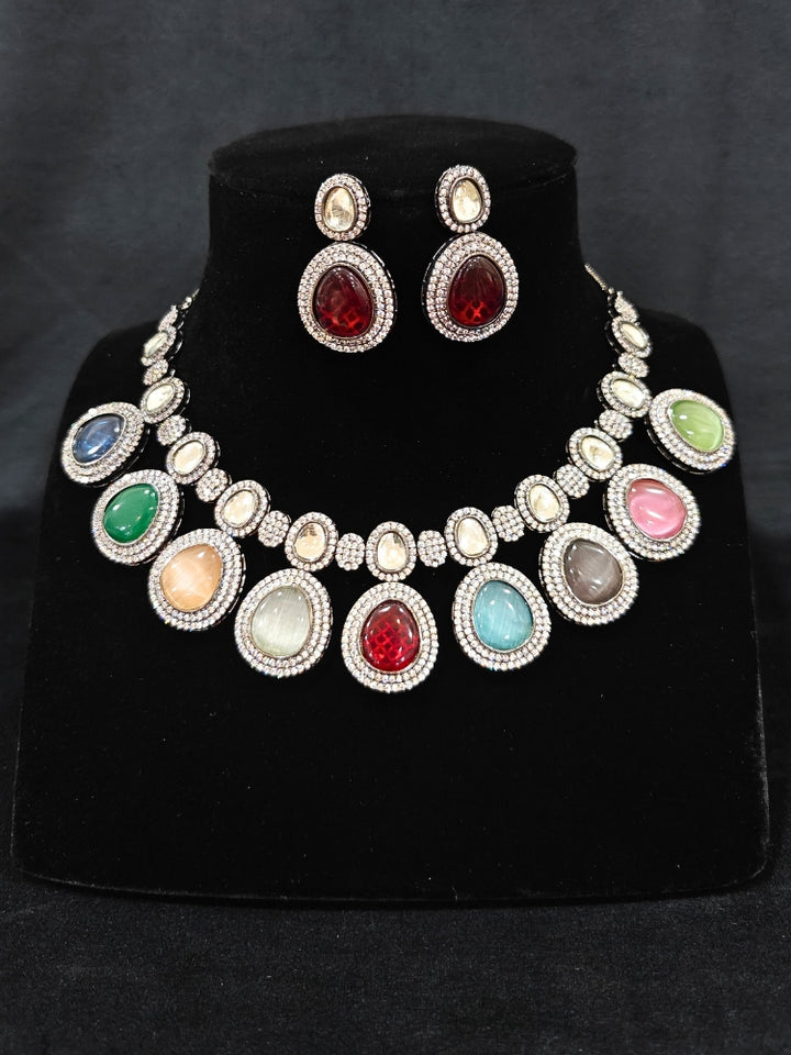 Close-up of ornate Indo-western American Diamond Multi-Color Collar jewellery set and earrings with American Diamonds and Monalisa Stones. Woman styling a statement American diamond necklace with an off-shoulder gown for a reception. Close-up of a luxury American Diamond imitation necklace styled.