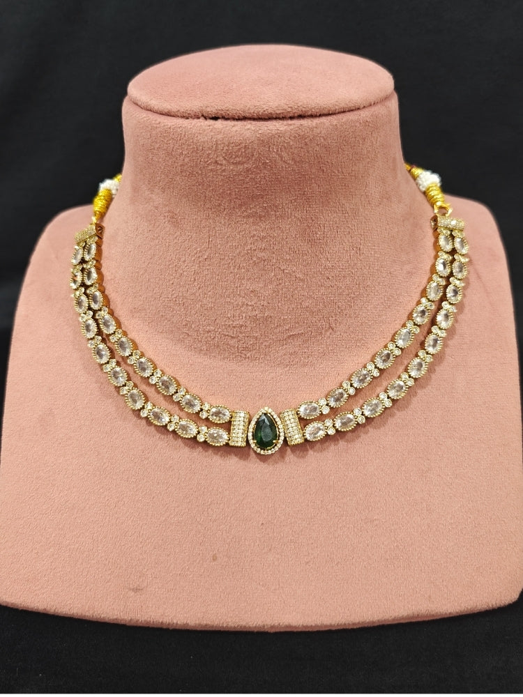 Close-up of an ornate Indo-western Green Collar Layered Diamond jewellery set and earrings with American Diamond and Colored Stones. Festive Diwali outfit styled with an American diamond artificial necklace. Party wear outfit completed with a lightweight American diamond necklace.