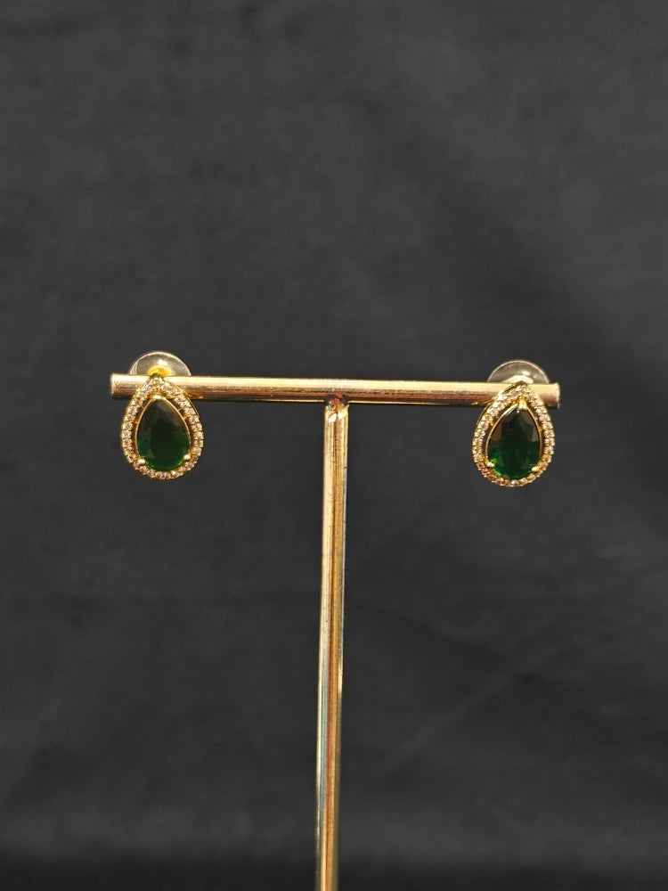 Close-up of an ornate Indo-western Green Collar Layered Diamond jewellery set and earrings with American Diamond and Colored Stones. Festive Diwali outfit styled with an American diamond artificial necklace. Party wear outfit completed with a lightweight American diamond necklace.