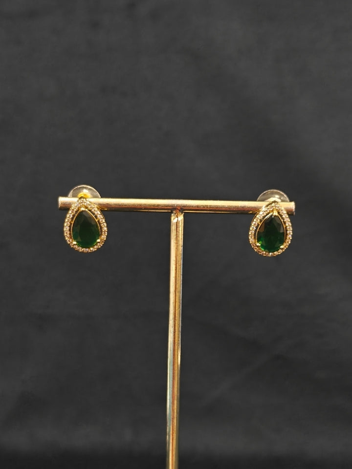 Close-up of an ornate Indo-western Green Collar Layered Diamond jewellery set and earrings with American Diamond and Colored Stones. Festive Diwali outfit styled with an American diamond artificial necklace. Party wear outfit completed with a lightweight American diamond necklace.