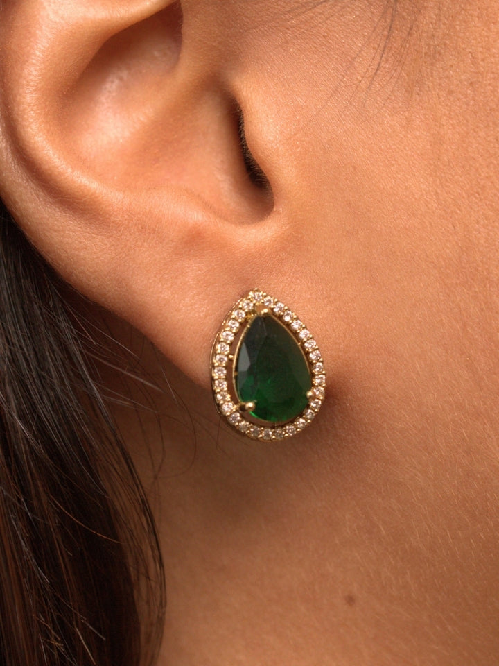 Close-up of a woman wearing an ornate Indo-western Green Collar Layered Diamond jewellery set and earrings with American Diamond and Colored Stones. Festive Diwali outfit styled with an American diamond artificial necklace. Party wear outfit completed with a lightweight American diamond necklace.
