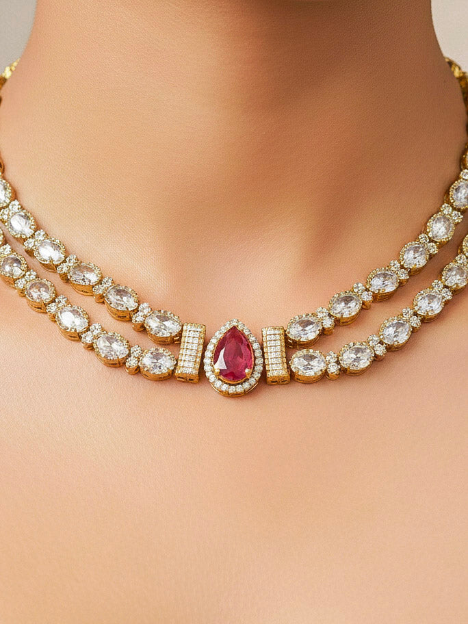 Close-up of a woman wearing an ornate Indo-western Red Collar Layered Diamond jewellery set and earrings with American Diamond and Colored Stones. Festive Diwali outfit styled with an American diamond artificial necklace. Party wear outfit completed with a lightweight American diamond necklace.