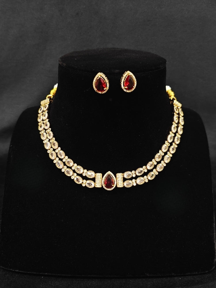 Close-up of an ornate Indo-western Red Collar Layered Diamond jewellery set and earrings with American Diamond and Colored Stones. Festive Diwali outfit styled with an American diamond artificial necklace. Party wear outfit completed with a lightweight American diamond necklace.