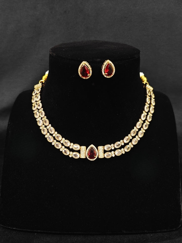 Close-up of an ornate Indo-western Red Collar Layered Diamond jewellery set and earrings with American Diamond and Colored Stones. Festive Diwali outfit styled with an American diamond artificial necklace. Party wear outfit completed with a lightweight American diamond necklace.