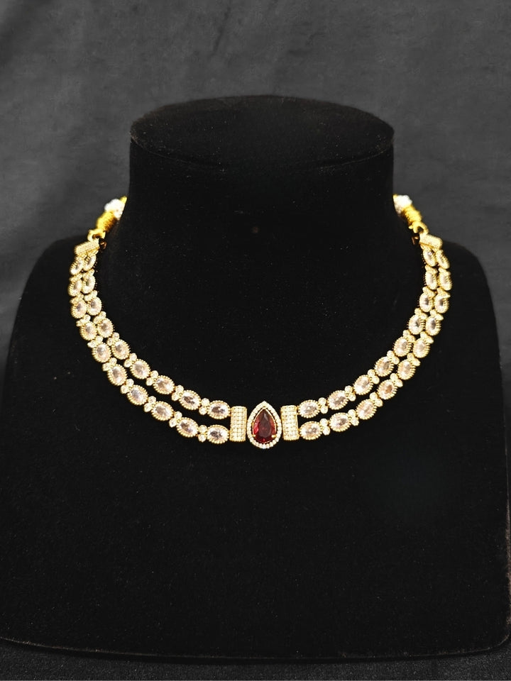 Close-up of an ornate Indo-western Red Collar Layered Diamond jewellery set and earrings with American Diamond and Colored Stones. Festive Diwali outfit styled with an American diamond artificial necklace. Party wear outfit completed with a lightweight American diamond necklace.