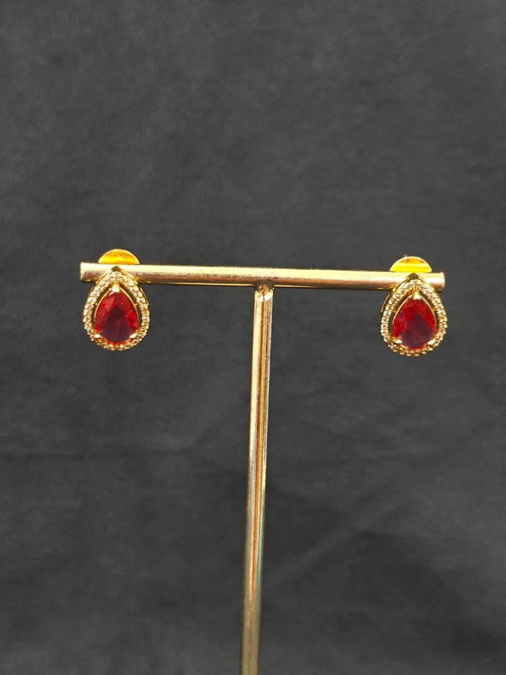 Close-up of an ornate Indo-western Red Collar Layered Diamond jewellery set and earrings with American Diamond and Colored Stones. Festive Diwali outfit styled with an American diamond artificial necklace. Party wear outfit completed with a lightweight American diamond necklace.