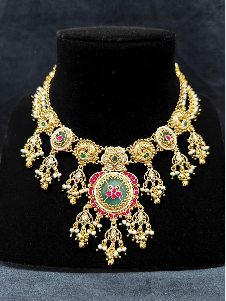 Close-up of an ornate traditional Heritage gold Collar jewellery set and earrings with Pearls and Colored Stone. Close-up of antique-style detailing in heritage artificial jewelry. Festive outfit styled with a royal heritage necklace.
