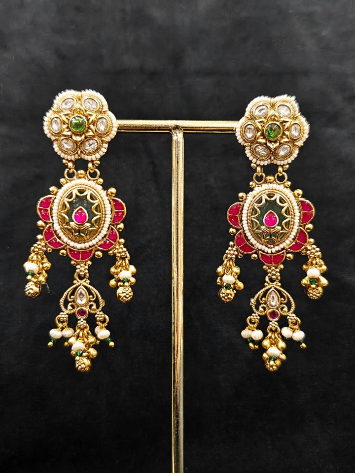 Close-up of an ornate traditional Heritage gold Collar jewellery set and earrings with Pearls and Colored Stone. Close-up of antique-style detailing in heritage artificial jewelry. Festive outfit styled with a royal heritage necklace.